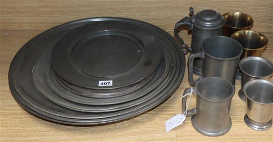 A collection of mixed pewter chargers, etc.